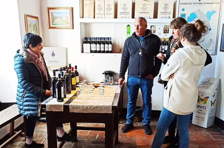 Small group enjoying guided Tuscan wine tasting in Montepulciano cellar door during private Cortona art and wine tour