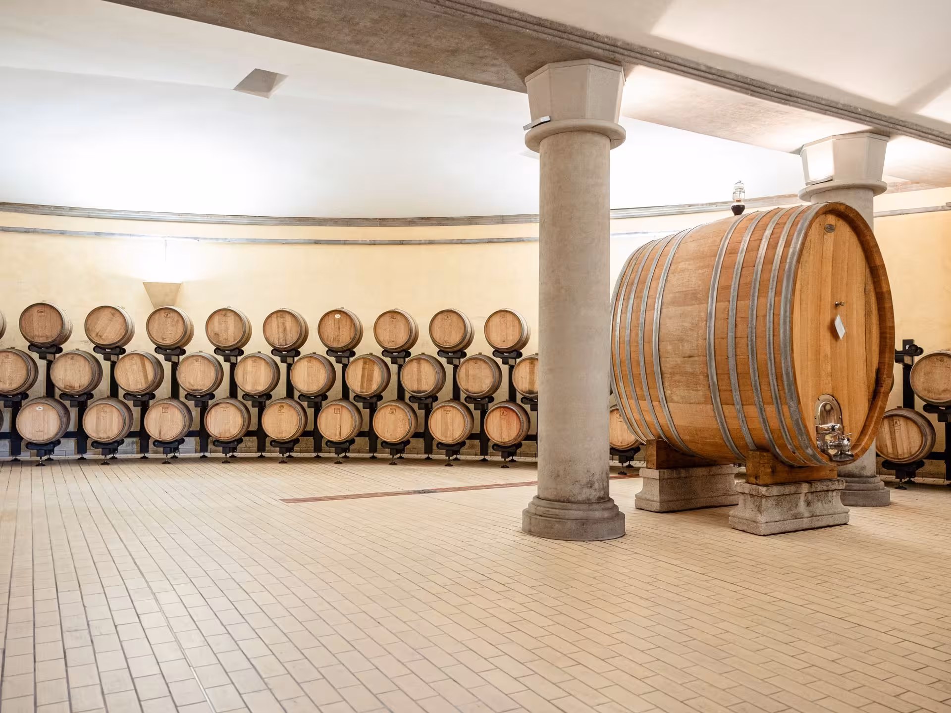 Barrel room with large wooden wine barrels in a Tuscan winery, ideal for a wine tour near Pisa.