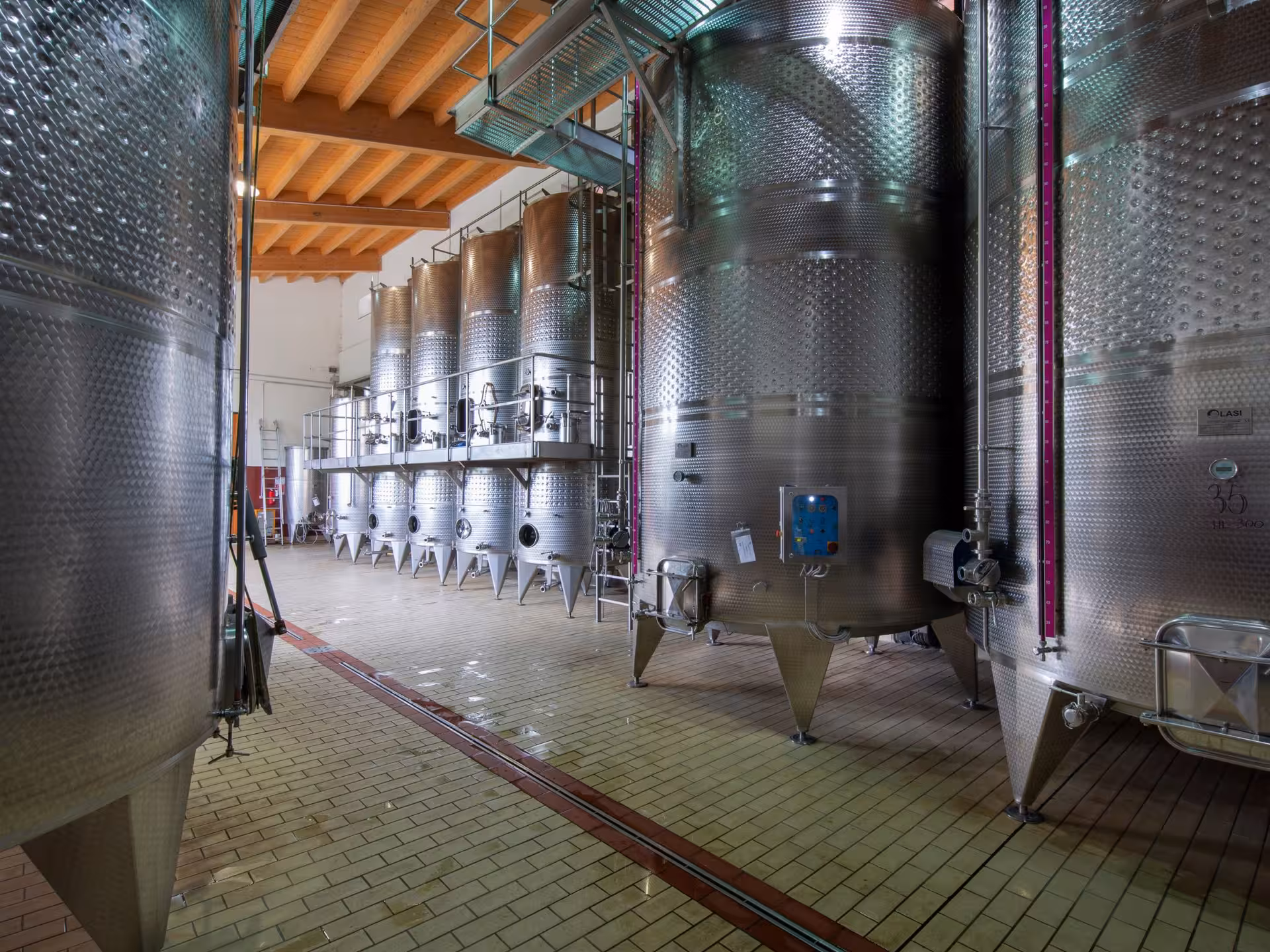 Stainless steel wine fermentation tanks in a modern Tuscan winery near Pisa, perfect for wine tasting tours.