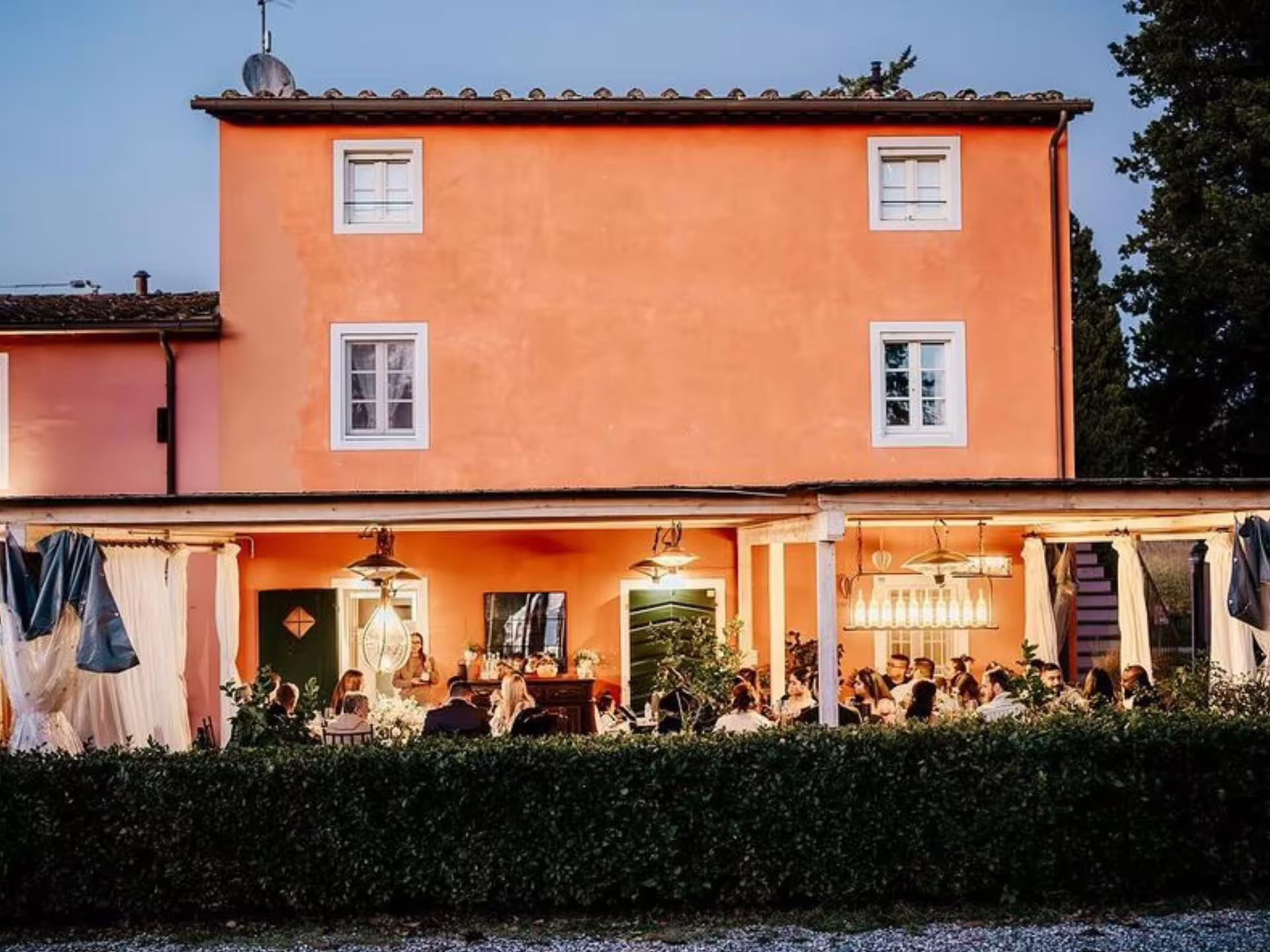 Charming Tuscan villa in Lucca hosting an evening winery tour and tasting experience under a cozy veranda.