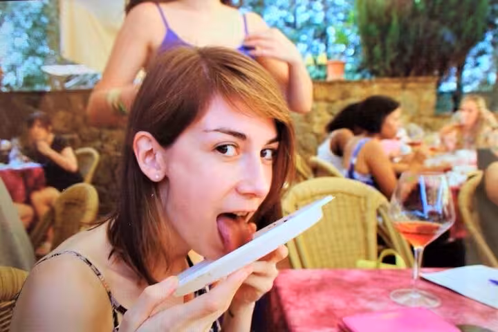 A woman enjoying a tasty lunch with friends on a Tuscany Vespa tour, highlighting Italian cuisine.