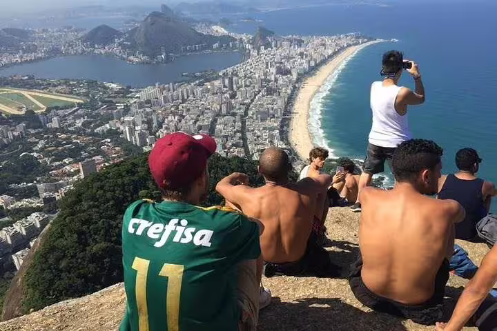Group of hikers enjoying the breathtaking view of Rio de Janeiro from Two Brothers Hill summit.