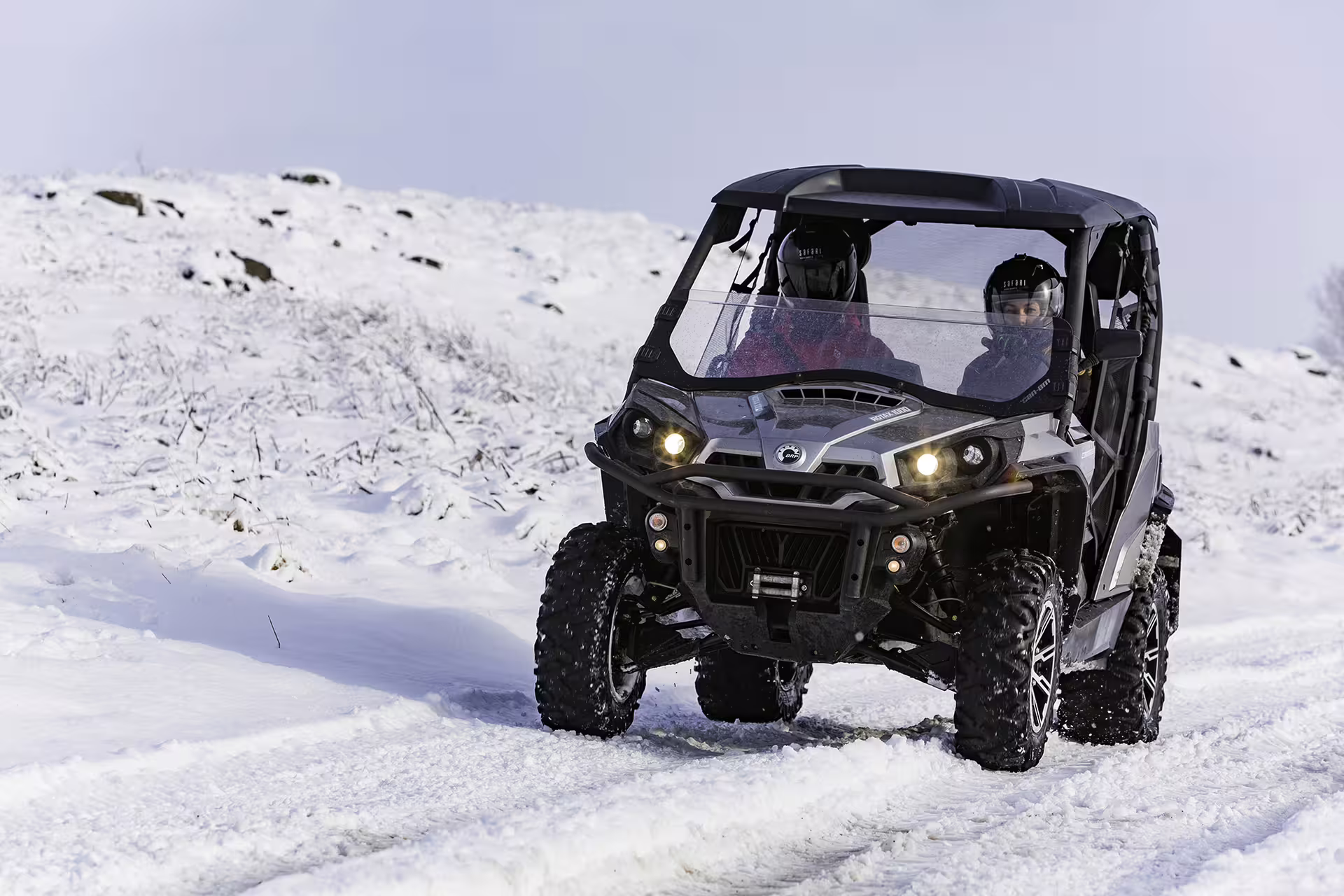 Two people driving a rugged buggy through snowy lava fields, showcasing adventure and thrill on a 2-hour Icelandic tour.