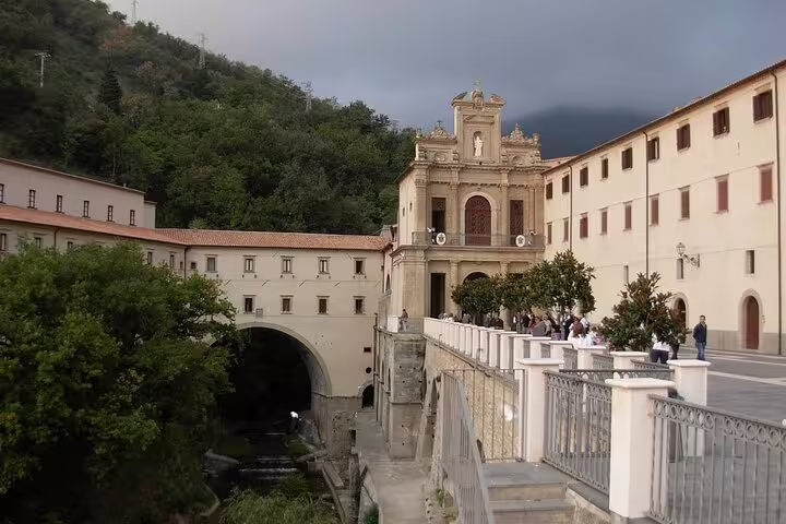 Visitors stroll past the historic sanctuary and arched bridge in a hilltop village on a Private Historical Walking Tour of the Tyrrhenian Cosentino