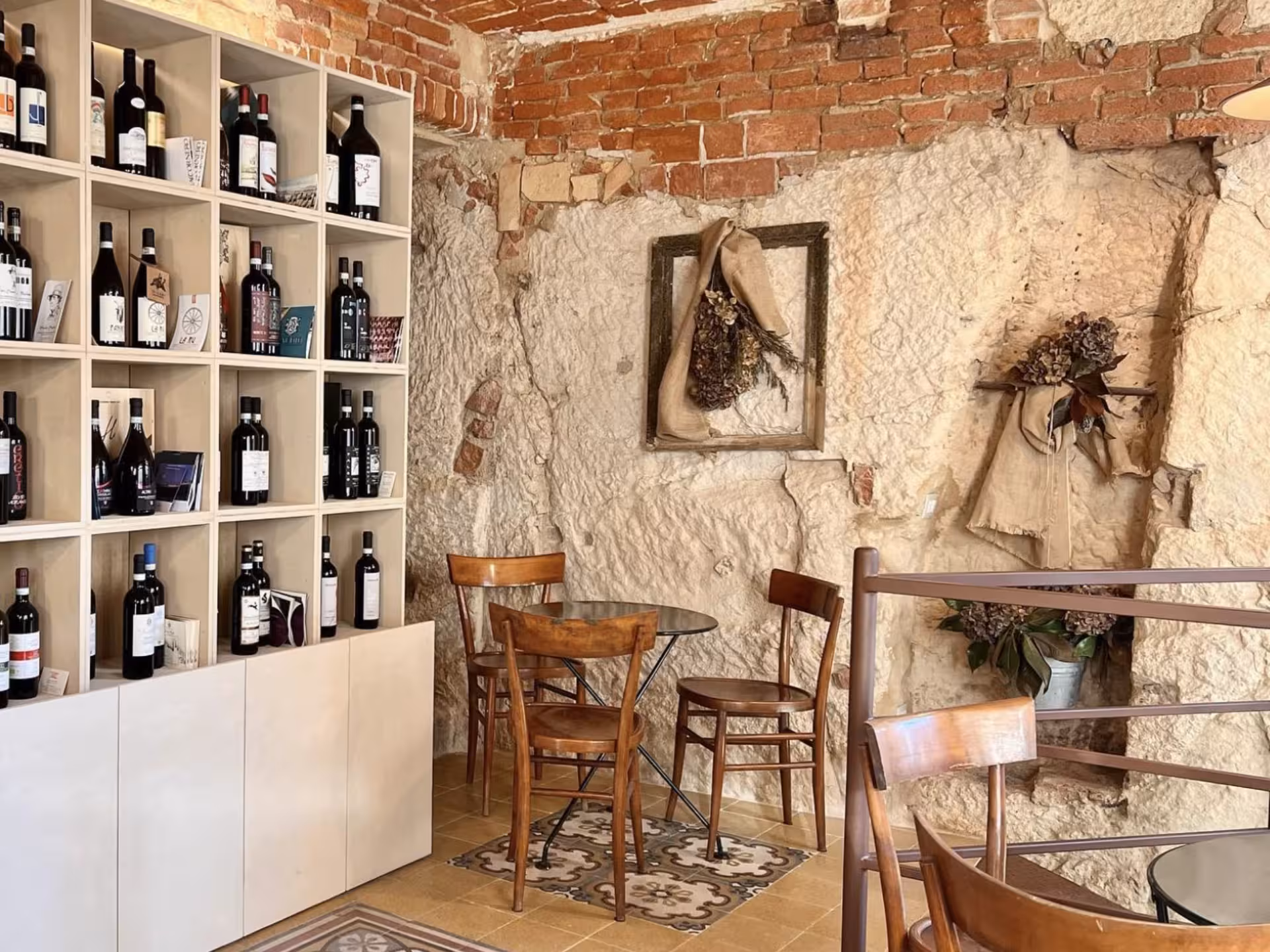 Cozy interior with wine bottles displayed on shelves, offering a warm ambiance for wine tasting near Asti.