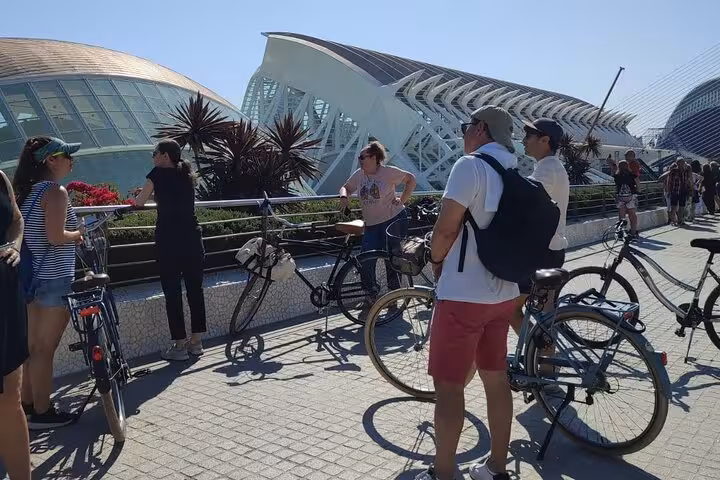 Guided bike tour group at Valencia City of Arts and Sciences, stopping for photos on a sunny day