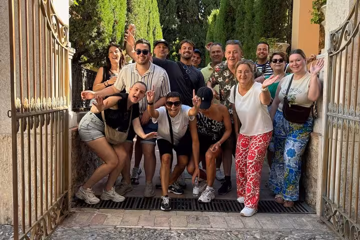 Happy group at a leafy entrance in Ruzafa, Valencia, after a guided bike tour of the city’s highlights