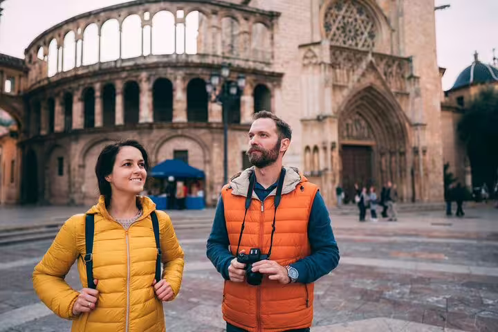 Tourists explore Valencia's historic architecture on a half-day private tour, capturing memories with local tasting experiences.