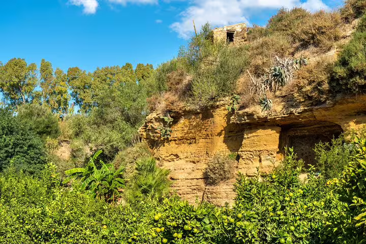 Lush citrus groves and rugged cliffs in the Kolymbethra Garden near the Valley of the Temples on a private guided Sicily tour