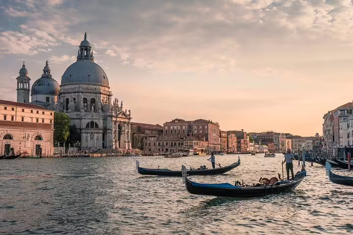 Traditional gondolas gliding past Santa Maria della Salute at dusk on a private, off-the-beaten-path Venice canal tour