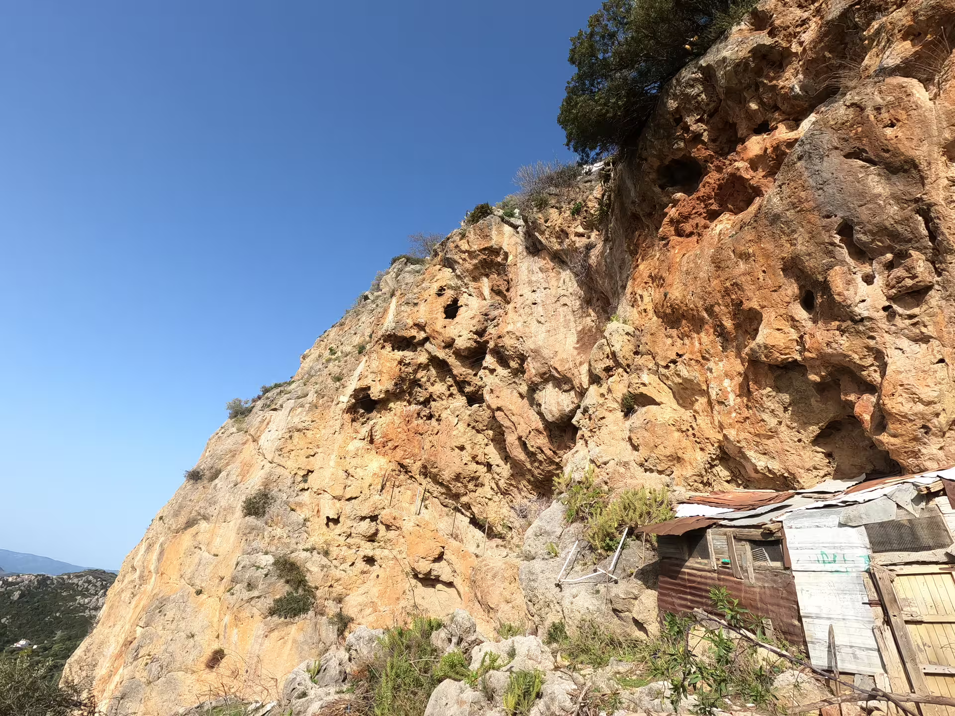 Rugged cliff face under clear blue sky, perfect for thrilling Via Ferrata adventure in Casares, Spain.