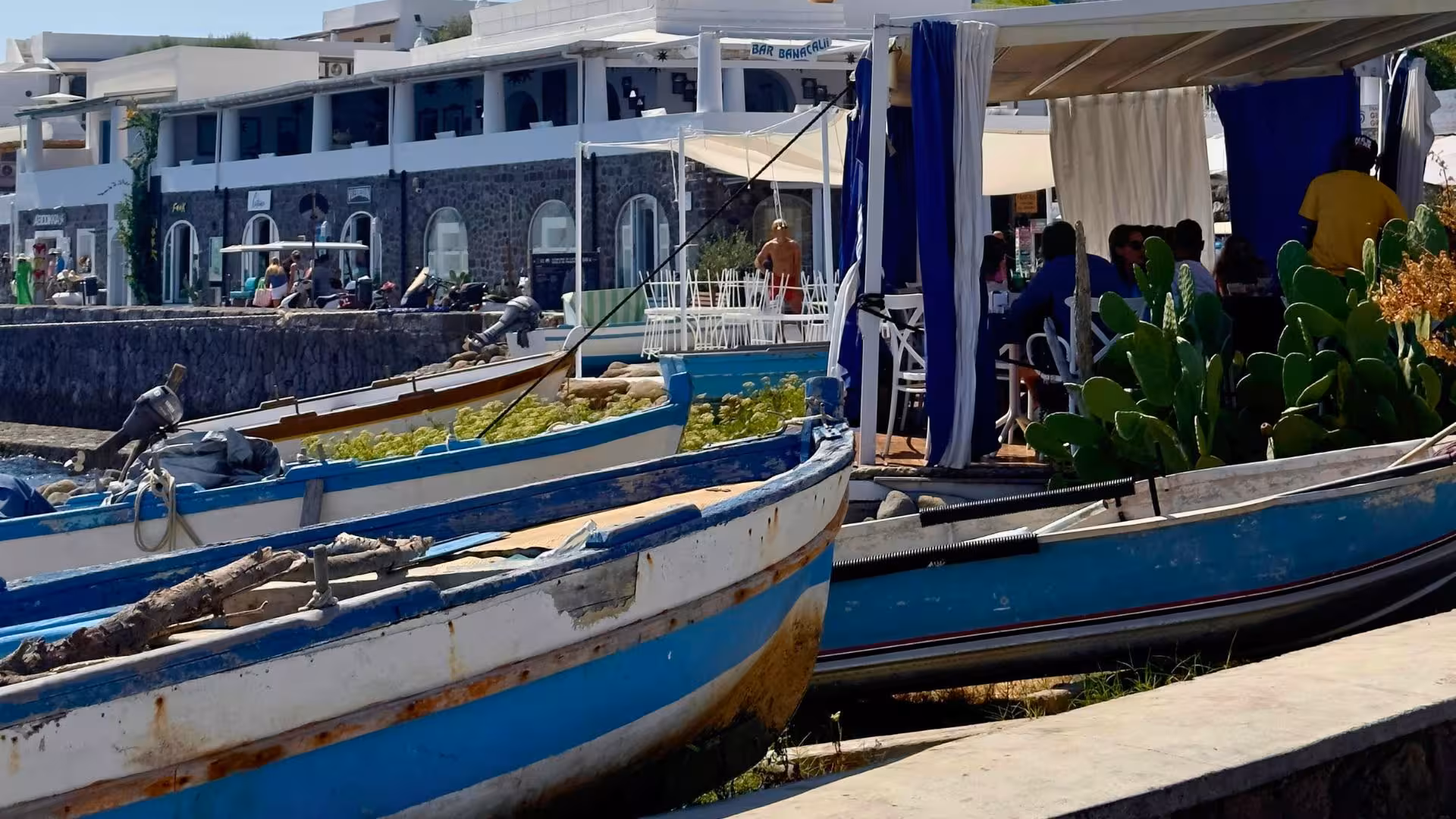 Charming waterfront with colorful boats and seaside café at Vibo Marina, ideal for Aeolian Islands motorboat tours.
