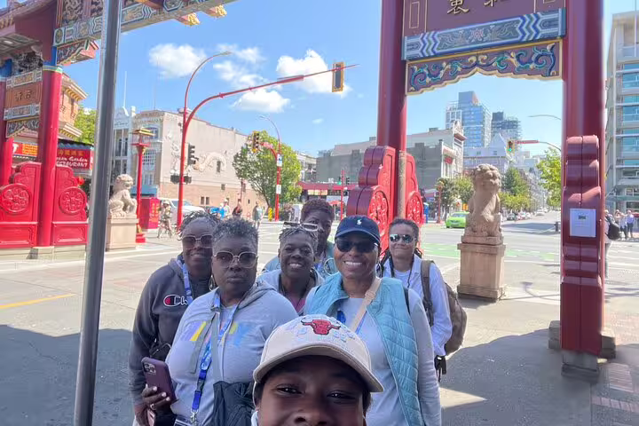 Group selfie at Victoria Chinatown Gate during a scavenger hunt and city highlights walking tour