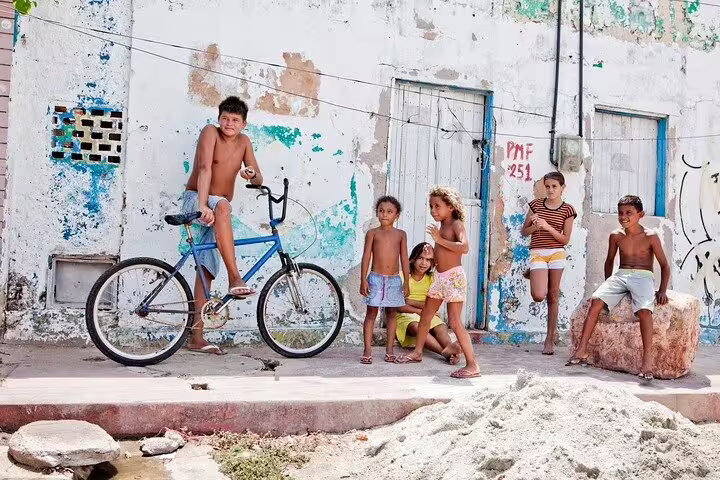 Children play by a colorful wall in Vidigal Favela, embodying local culture on the Hike Two Brothers Hill tour.