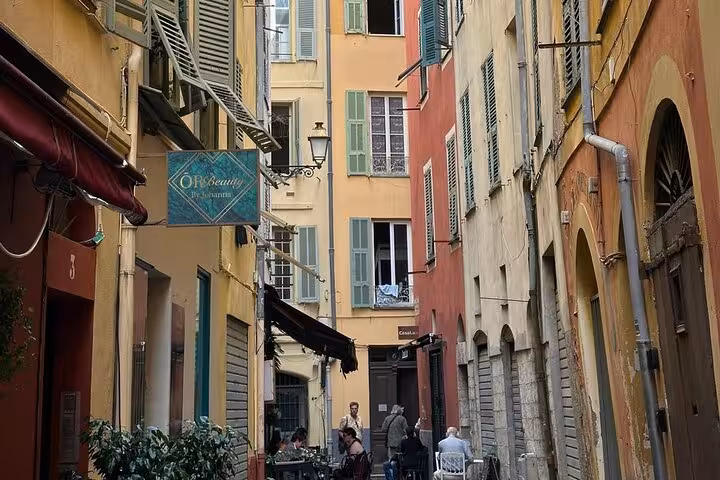 Narrow alley in Vieux Nice with pastel buildings and cafes, ideal for a Cannes Nice Eze Monaco private tour