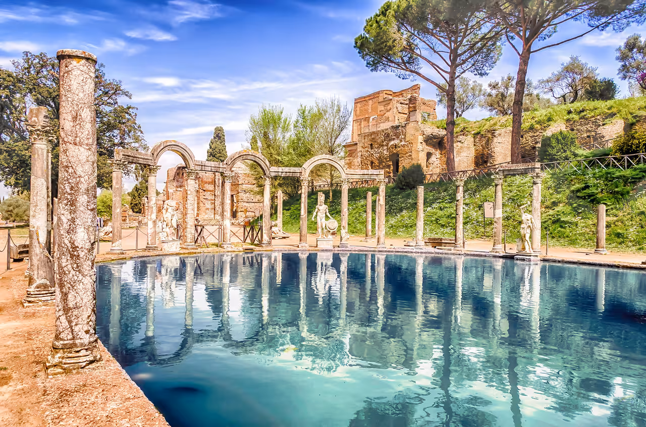 Ancient pool and marble statues at Villa Adriana in Tivoli on a sunny day, featured on a Rome day trip tour