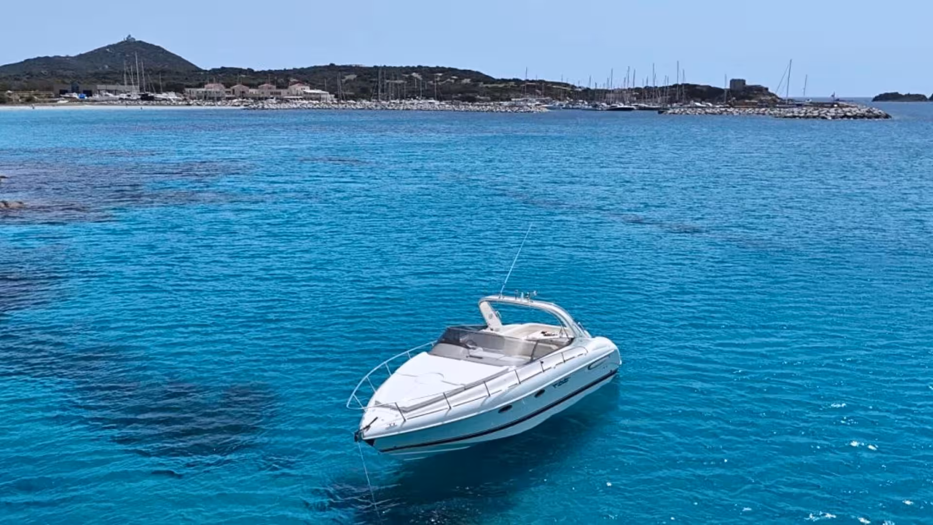Private speedboat anchored in Villasimius crystal-clear waters, perfect for exclusive Sardinian tours.