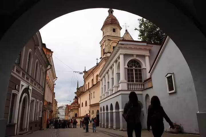 Vilnius Old Town street under archway with historic buildings, part of a self-guided scavenger hunt tour