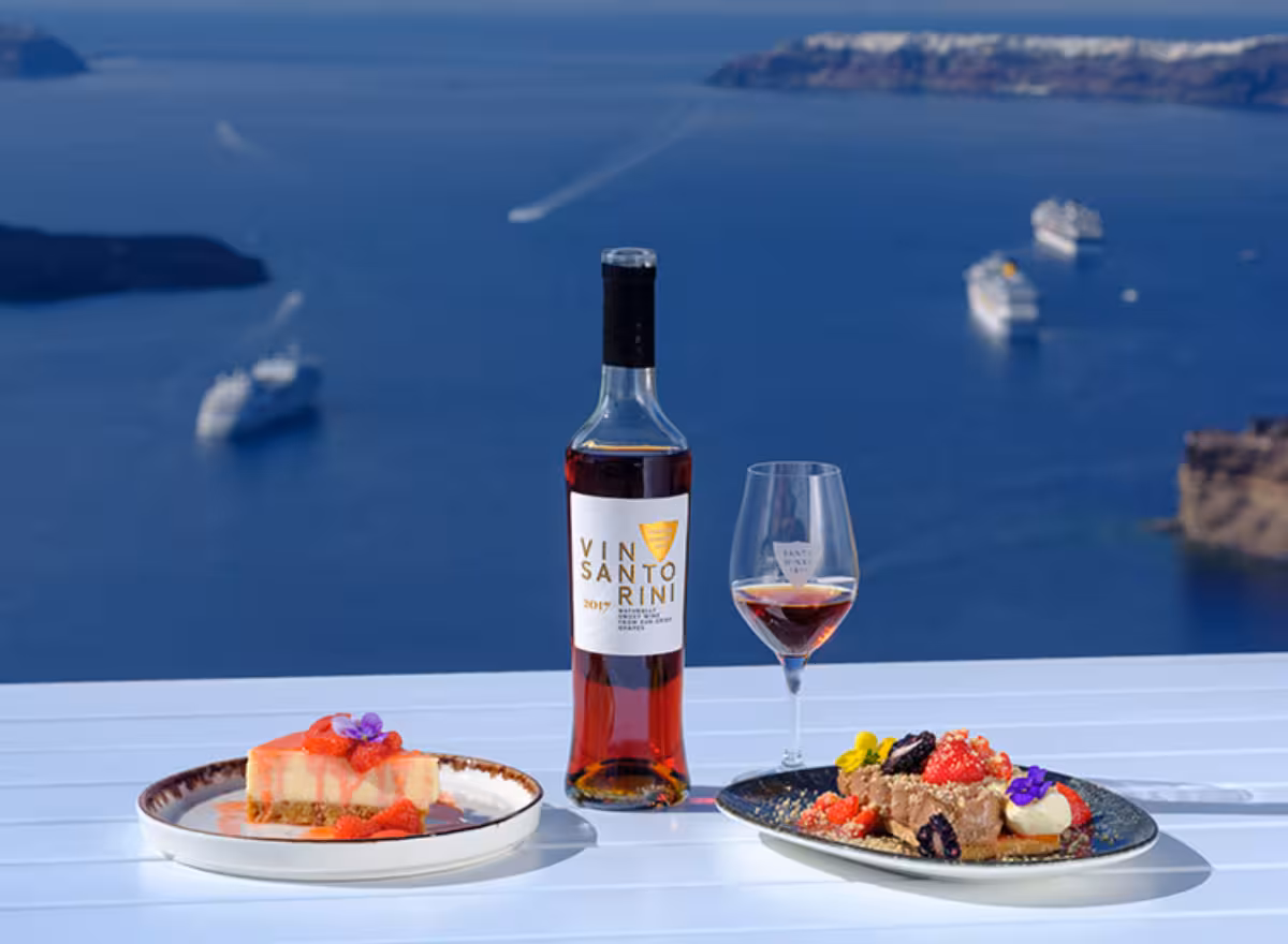 Vinsanto wine and dessert pairing at Santo Winery, Santorini caldera view dining experience with Aegean backdrop