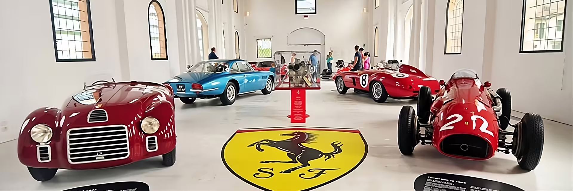 Vintage Ferrari race cars on display inside Enzo Ferrari Museum Modena, included with entrance ticket