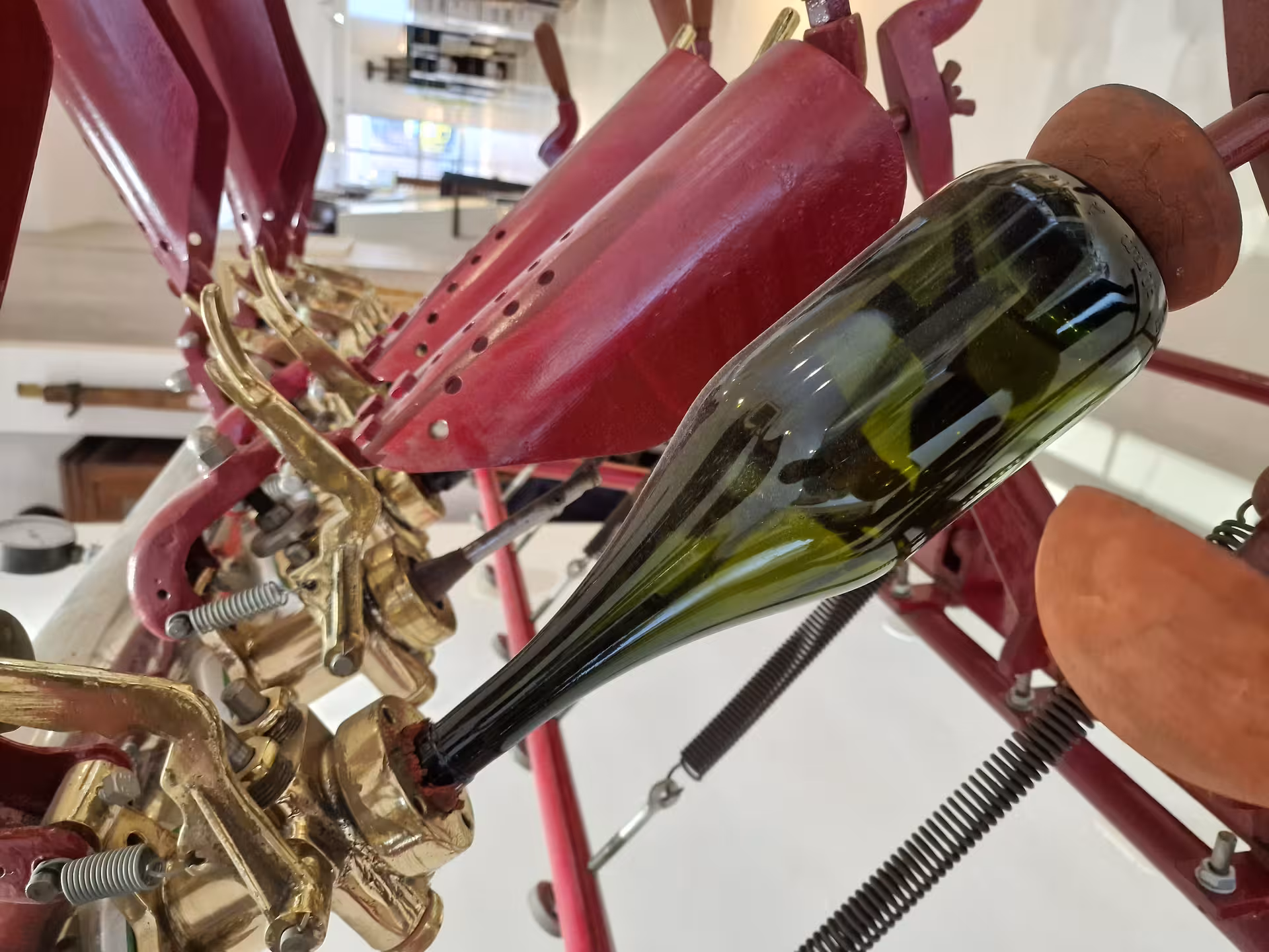 Close-up of a vintage bottling machine with a wine bottle, showcasing traditional winemaking on a gourmet tour.