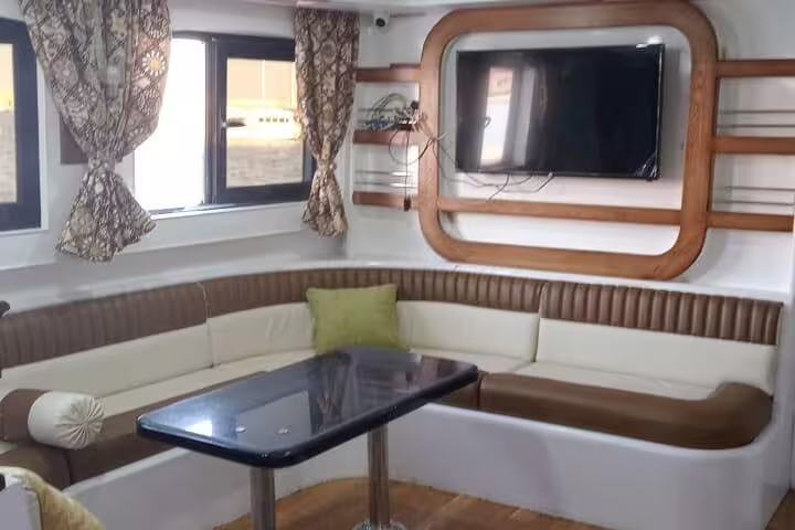 VIP boat lounge with comfy seating and TV for Dolphin House snorkeling day trip from Hurghada