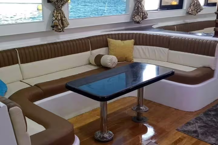 VIP boat lounge seating on Hurghada Dolphin House snorkeling day trip, comfy cabin with sea view windows