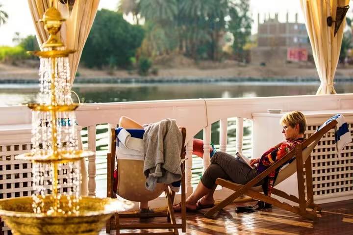 Guest relaxing on VIP Dahabiya sun deck, Nile cruise Luxor to Aswan 4 nights 5 days with luxury amenities