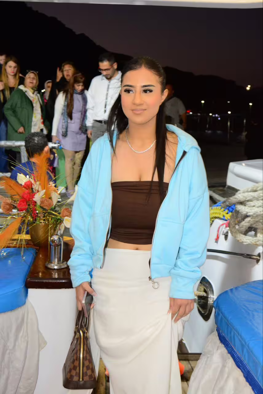 Guest posing on VIP dinner cruise boat in Sharm El Sheikh marina at night, Red Sea evening tour