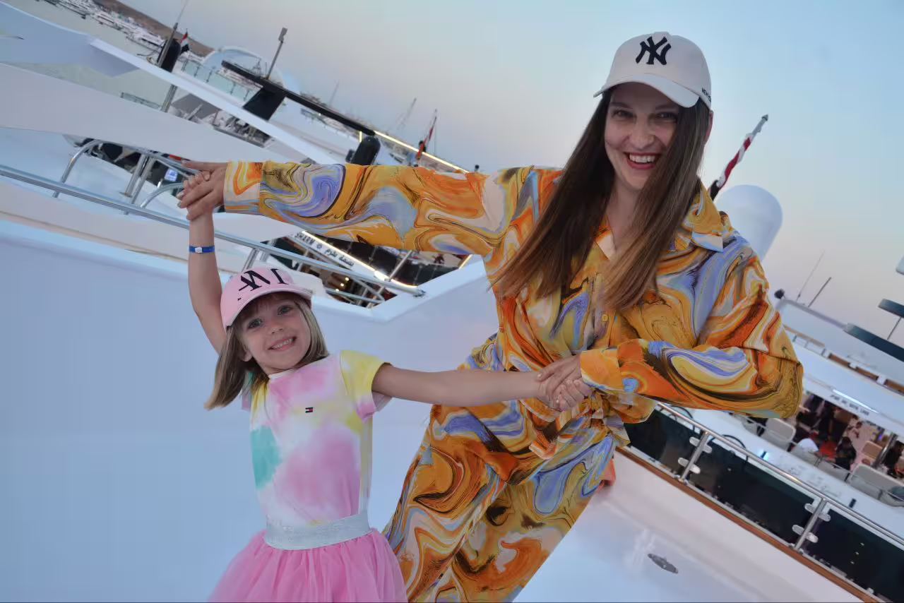 Mother and daughter dancing on VIP boat deck during Sharm El Sheikh dinner cruise at sunset marina