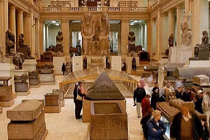 Inside Grand Egyptian Museum gallery with pharaoh statues and sarcophagi on VIP Giza Pyramids wonders tour