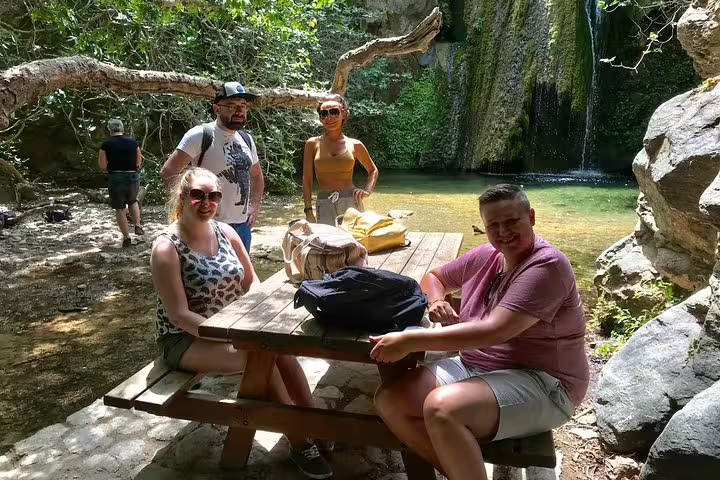 Group enjoying a serene picnic by a waterfall on a VIP luxury 4x4 LandRover tour.