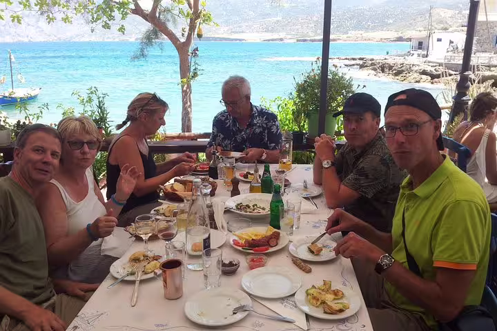 Group enjoying a seaside meal with stunning views on a VIP Luxury Private Tour in Crete.