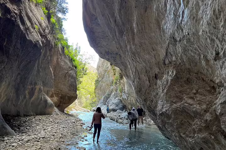 Adventurers explore a stunning rocky canyon stream, part of a VIP Luxury Private Tour with LandRover 4x4 excursion.