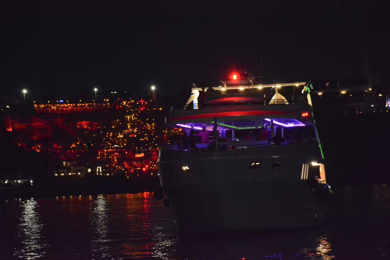 VIP yacht cruising at night in Sharm El Sheikh with colorful lights, Red Sea reflections and dinner cruise vibes