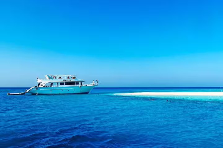 VIP yacht anchored near a sandbank on the Hurghada Dolphin House snorkeling tour in crystal-clear Red Sea