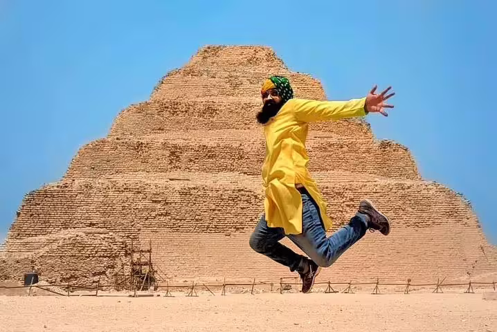 Visitor jumping in front of Saqqara Step Pyramid, highlight of Cairo tour including Giza, Memphis and Dahshur