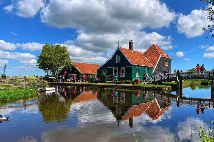 Volendam waterfront houses and bridge reflected in calm water, highlight of private day tour from Amsterdam