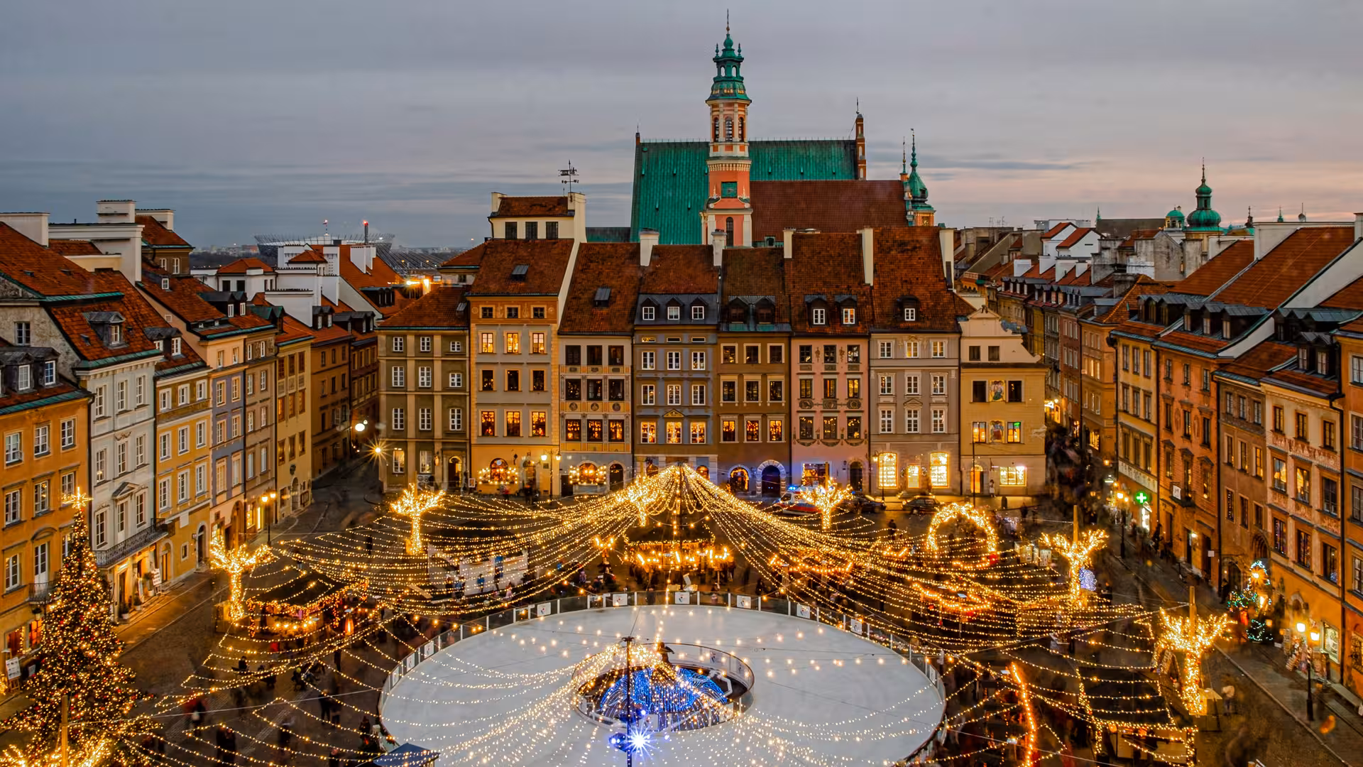 Experience Warsaw's enchanting Old Town Square adorned with festive lights and a charming ice rink during winter.