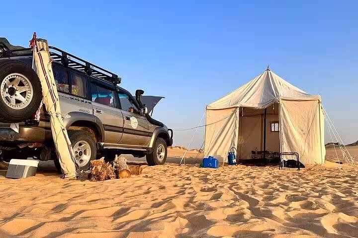 4x4 jeep and Bedouin-style camp tent set on dunes for an overnight White Desert & Black Desert 2-day private tour