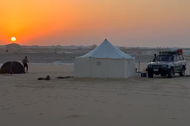 Sunset desert camp with white tent and 4x4 in Egypt, White Desert & Black Desert 2-day private tour