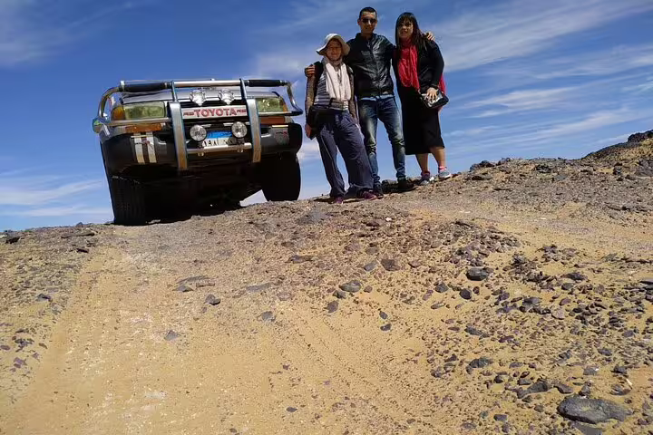 Group photo beside Toyota 4x4 on Bahariya Oasis desert track, White Desert overnight camping adventure
