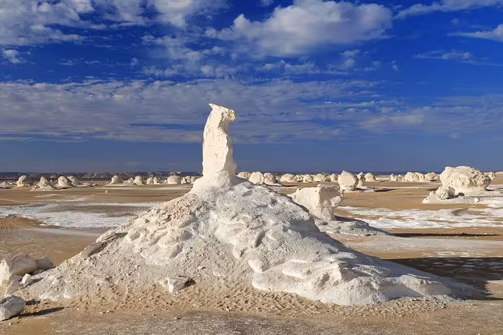 Chalk rock pinnacle in Egypt’s White Desert on overnight camping tour from Bahariya Oasis under blue skies