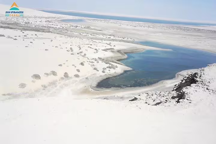 Scenic White Desert oasis lagoon in Egypt, a stop on 15-day Cairo Luxor Aswan and Oasis tour package