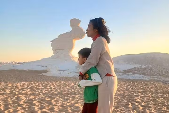 Sunset at White Desert Egypt, travelers by chalk rock formations on a 2-day private White & Black Desert tour