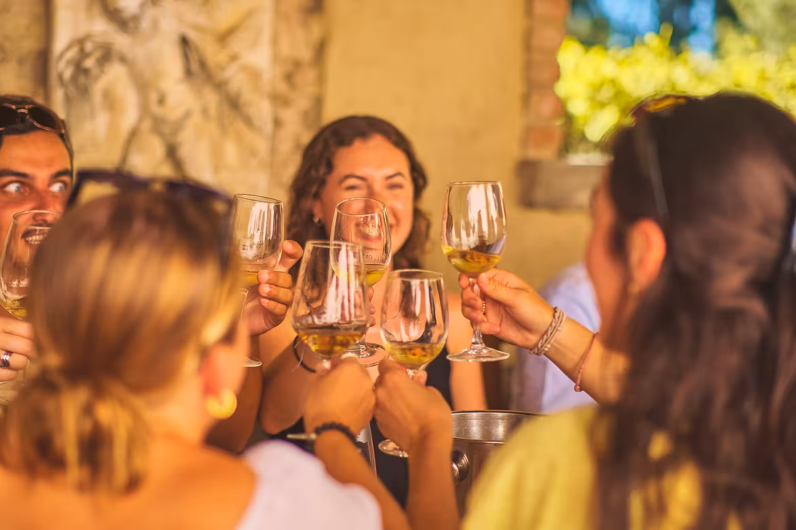 Group toasting with wine glasses during a lively small-group wine blending experience.