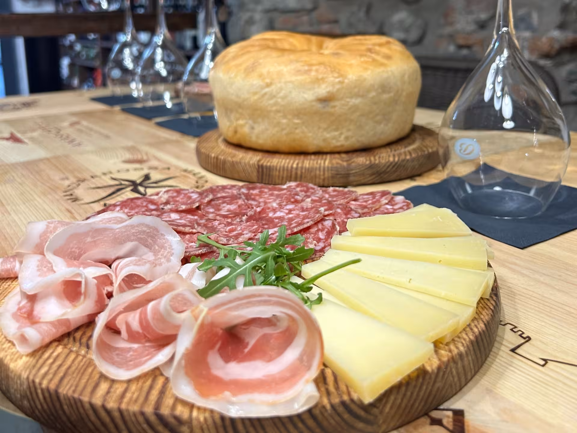 Charcuterie and cheese platter with fresh bread set for wine tasting at Lake Como, ideal for gourmet food lovers.