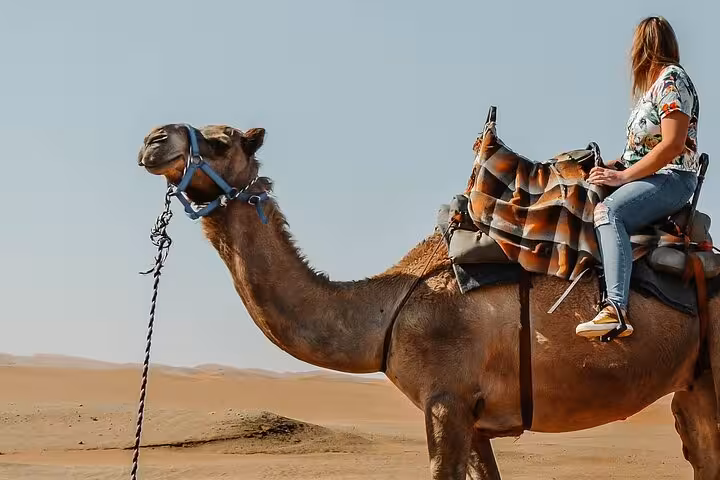Woman on camel in Hurghada desert dunes, one-hour camel riding adventure with transfer from Hurghada hotels