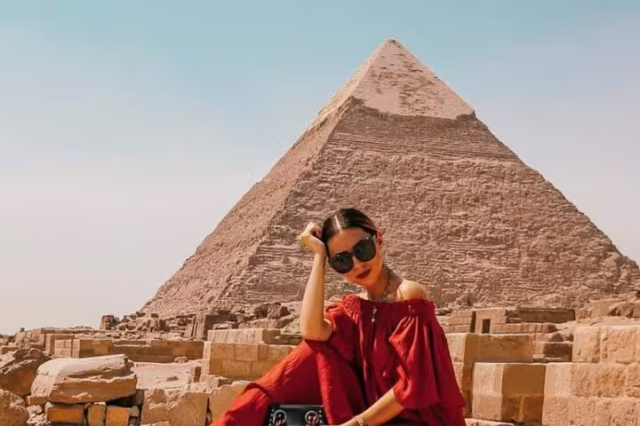 Woman in red dress posing at the Pyramids of Giza for a private Cairo photo session add-on tour and photos