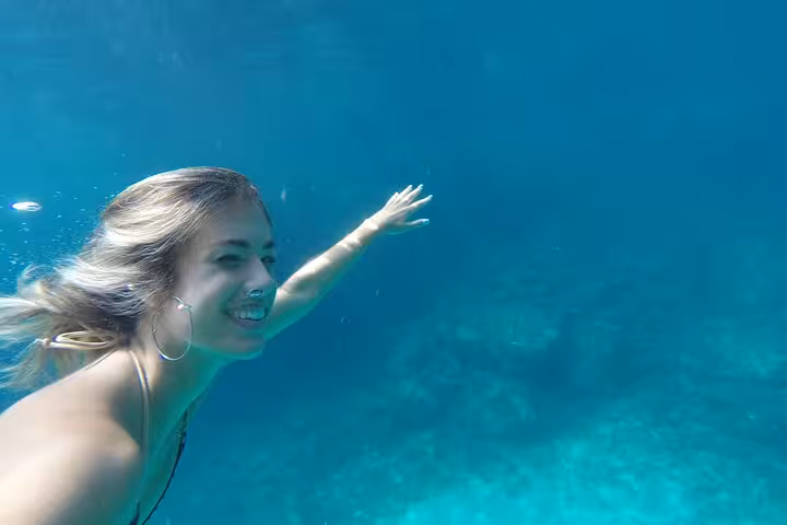 Woman snorkeling in clear Mediterranean water during a Calanques National Park hiking tour from Marseille